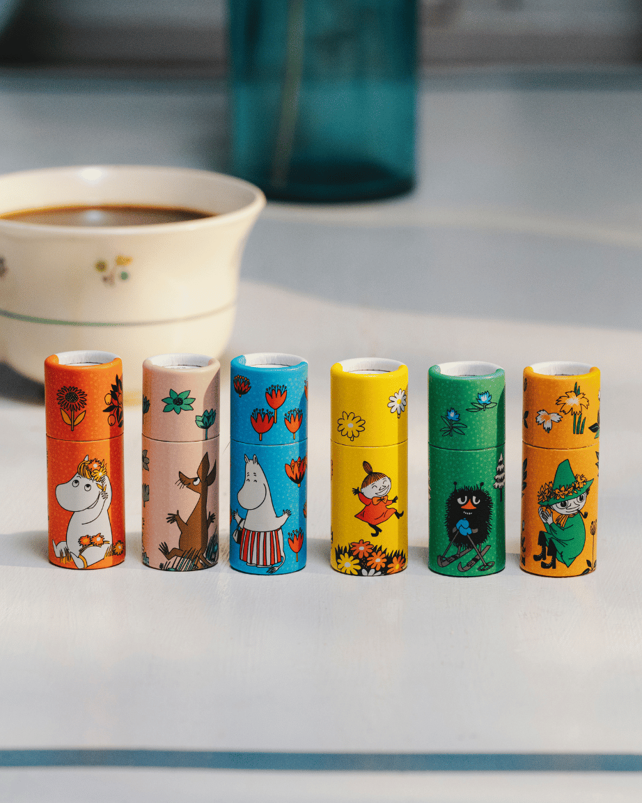 Läppcerat av Gustaf & Linnea med Mumin motiv som står på ett bord.