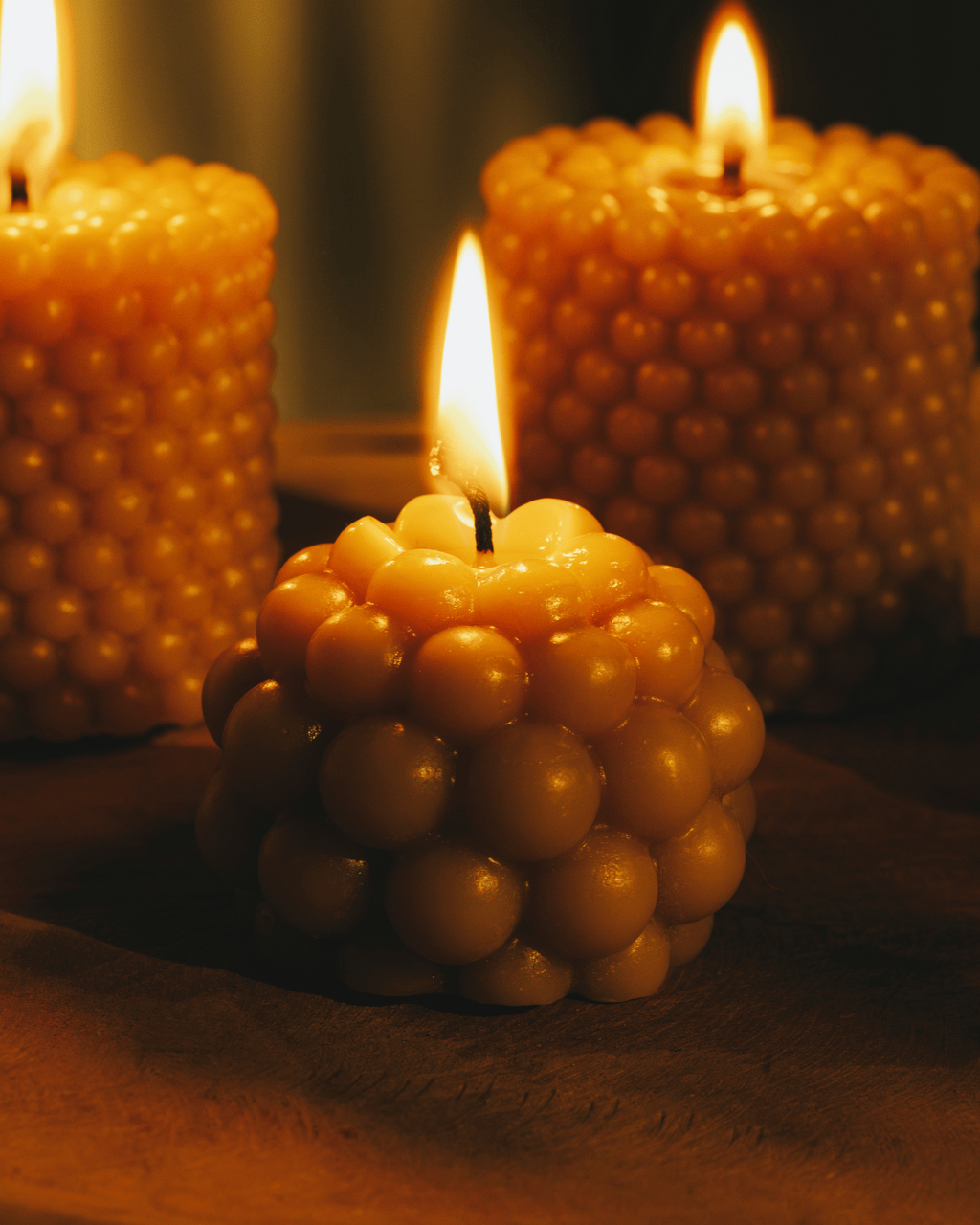 Several beeswax candles lit on a table.