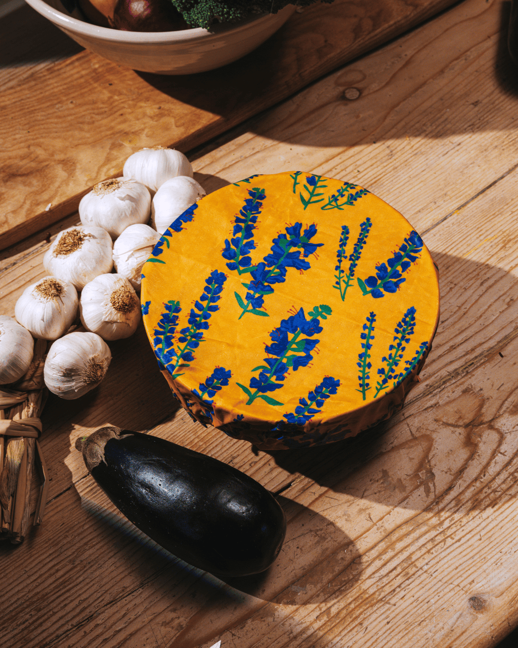A beeswax wrap a bluefish motif over a bowl.