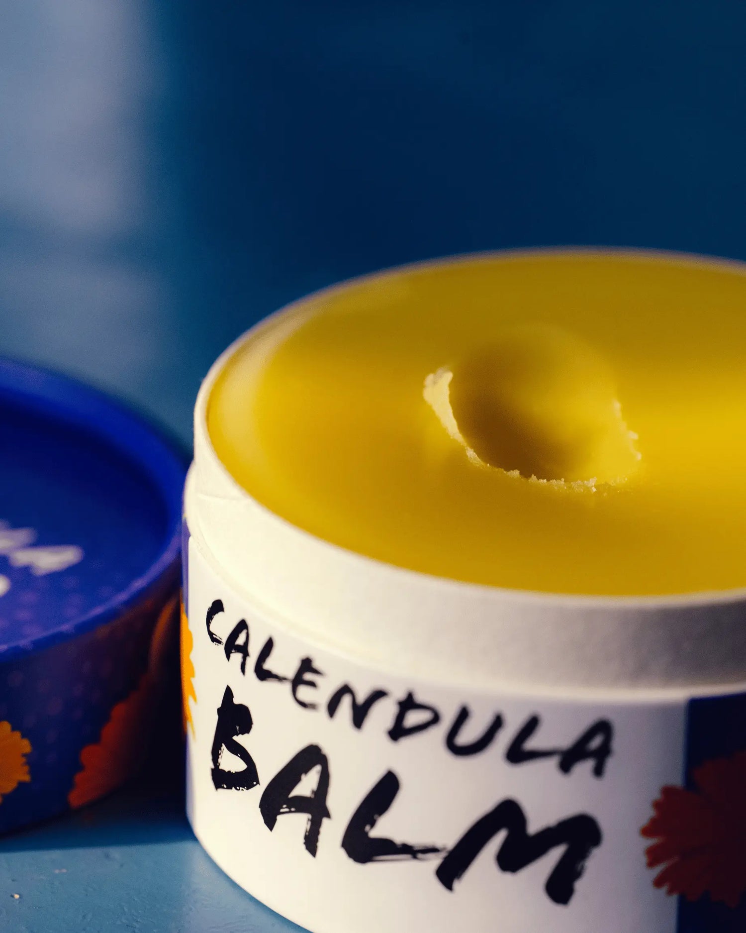 An opened jar of calendula ointment.