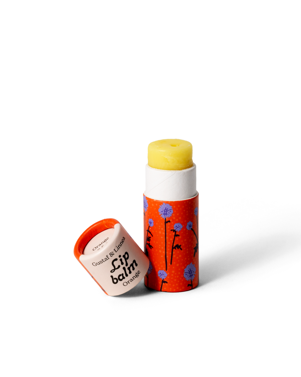 Lip balm , opened tube with yellow lip balm a pattern of thistles.