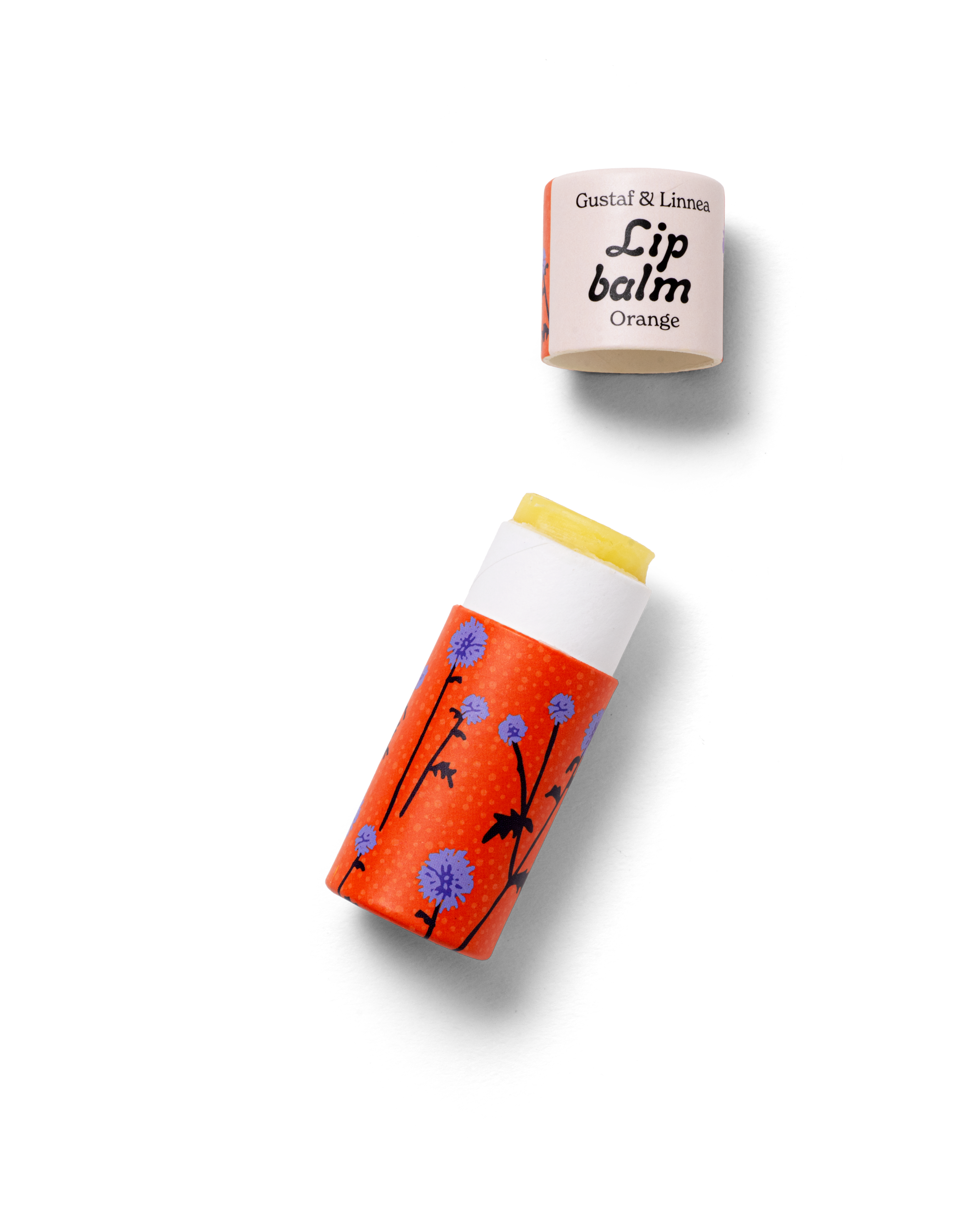 Handgjort läppcerat Orange med bolltistelmönster, visat öppet med lock vid sidan.