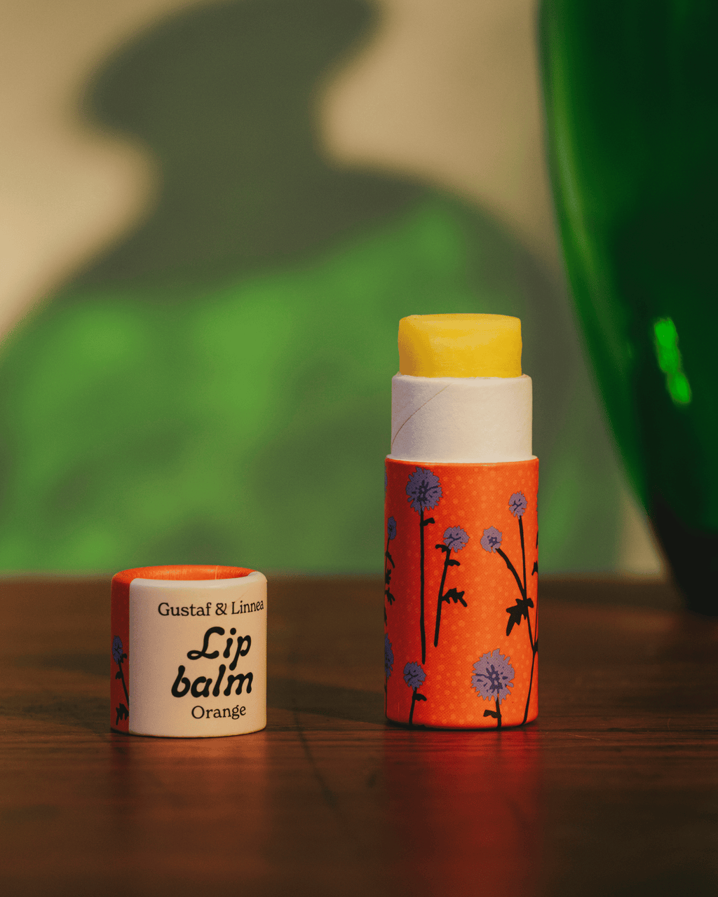Lip balm orange flavor and thistle motif.